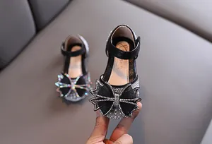 Vue détaillée de chaussures de fête noires pour filles avec un grand nœud en strass