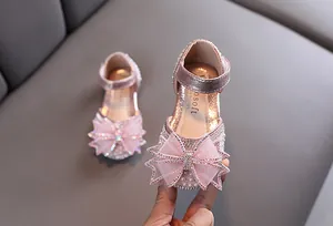 Détail de chaussures de princesse roses pailletées pour fille avec gros nœud