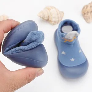 Primer plano de la suela de goma suave y muy flexible de un zapato calcetín para bebé azul