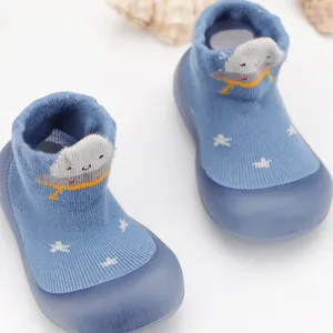 Detalle de zapatos de calcetín para bebé con suela blanda y dibujo de OVNI azul