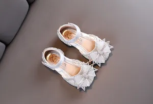 Vue de dessus de chaussures argentées pour filles avec nœuds décoratifs et paillettes.
