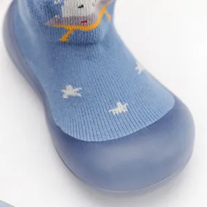 Detalle de zapatos de punto azules para bebé con suela de goma suave