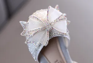 Gros plan sur un nœud en strass scintillant sur d'élégantes chaussures de princesse