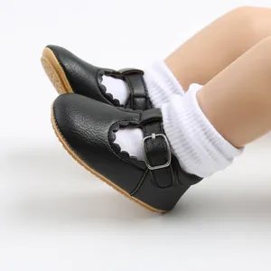 Close-up detail of black baby Mary Jane princess shoes with scalloped edges and silver buckle