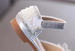 Détail des perles et des strass sur des chaussures de princesse argentées pour filles