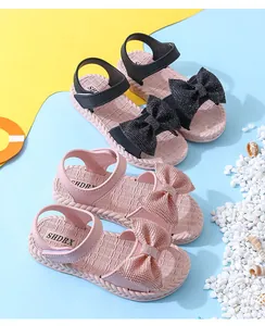 Elegant girls' summer sandals with large glittery bows in pink and black colors.