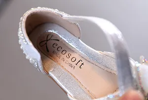 Vue macro montrant la texture pailletée argentée et le bord en perles d'une chaussure de fille