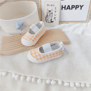 Detalle de zapatos para caminar para bebé a cuadros naranjas con suela muy blanda