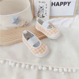 Detalle de los zapatos de lona a cuadros naranjas para niñas con una cómoda banda elástica