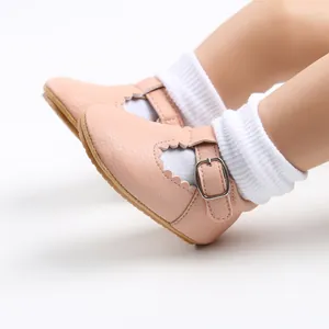Close-up of pink baby girl princess shoes with scalloped edges and buckle strap