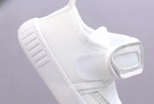 Close-up detail of white breathable mesh baby walking shoe with Velcro strap