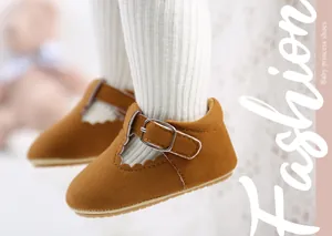 Close-up of brown suede baby princess shoes with buckle and scalloped edge