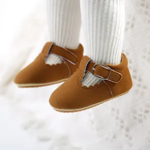 Close-up detail of brown suede baby princess walking shoes with buckle and scallop trim