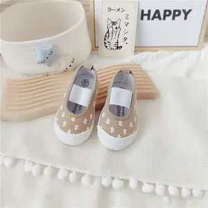 Detalle de zapatos de lona para niñas con estampado floral y correas elásticas suaves