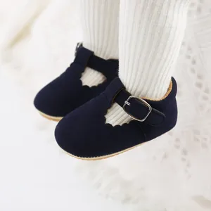Close-up of navy blue baby Mary Jane shoes with scalloped edges and buckle strap.