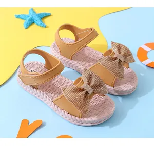 Girls' summer sandals with a large glittery bow and a soft pink textured sole.