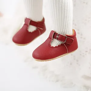 Close-up of red baby princess walker shoes with scalloped edges and T-strap buckle