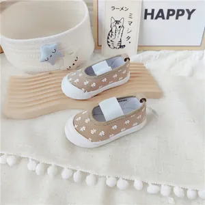 Detalle de los zapatos de lona con flores caqui para niñas pequeñas con banda elástica