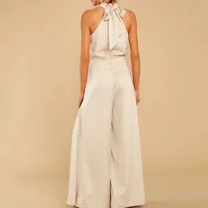 Rückansicht eines eleganten cremefarbenen Neckholder-Jumpsuits mit modischer Schleife am Hals