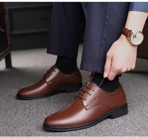 Detailansicht eines Mannes, der hochwertige braune Business-Schuhe aus Leder anzieht