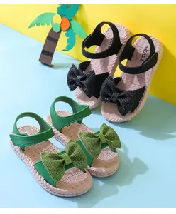 Detailed view of children's beach sandals featuring sparkling bows in green and black