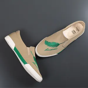 Detailweergave van kaki instapschoenen voor heren met groene verenborduursels