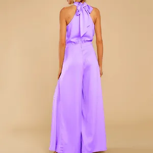 Rückenansicht eines eleganten lila Satin-Halterneck-Jumpsuits mit einer großen Schleife