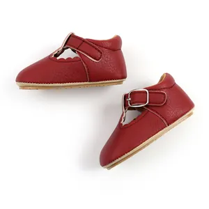 Detailed view of red textured leather baby Mary Jane shoes with soft rubber soles.