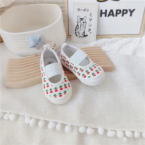 Detalle de zapatos de lona para bebé blancos con flores de tulipán y cinta elástica