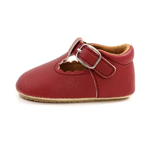 Side view of red baby princess shoes with scalloped edges and metal buckle strap.