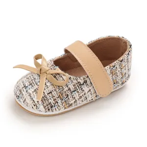 Detail eines Baby-Lauflernschuhs aus Tweed mit weicher Sohle und Schleife für Mädchen