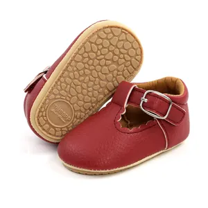 Detail of red baby girl princess shoes showing the non-slip rubber sole and T-strap