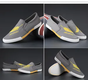 Modieuze grijze canvas slip-on herenschoenen met geel vederborduursel detailzicht.