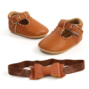 Dettaglio delle scarpe da principessa per neonati marroni e fascia con fiocco set