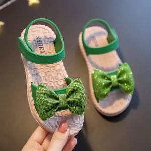 Green girls sandals with sparkling glitter bows and soft woven soles for summer beach