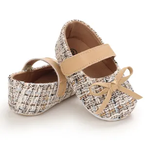 Nahaufnahme von eleganten Baby-Tweed-Mary-Jane-Lauflernschuhen mit beiger Schleife im Detail
