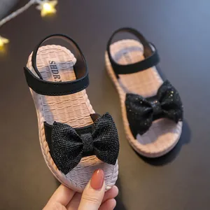 Charming girls' black summer sandals with glittery bows and soft woven pink soles
