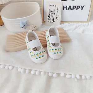 Detalle de zapatos de lona para bebé con flores y suela blanda y correa elástica para niña