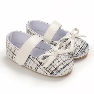 Detailansicht der eleganten weißen Tweed-Baby-Mary Jane-Schuhe mit Schleife und Klettverschluss