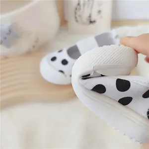 Detalle de suela blanda y flexible en zapatos de lona con lunares para bebés niñas