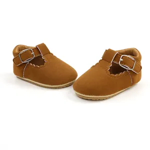 Detail of brown suede baby girls walking shoes with scalloped edges and buckle