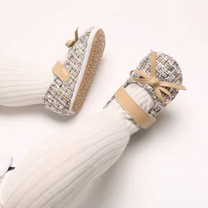 Nahaufnahme von Tweed-Baby-Prinzessin-Lauflernschuhen mit Schleife und weicher Gummisohle
