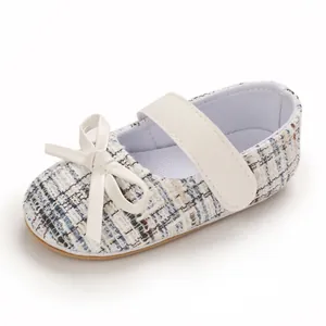 Nahaufnahme eines Prinzessinnen-Babyschuhs aus Tweed mit weißer Schleife und Riemen