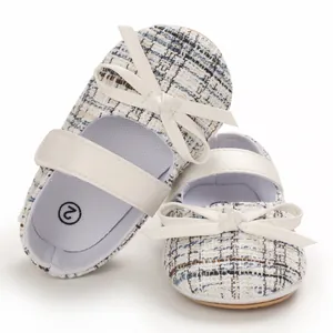 Nahaufnahme von eleganten Baby-Mädchen Tweed-Schuhen mit einer klassischen weißen Schleife