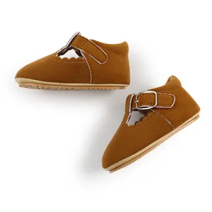 Top-down view of brown suede baby princess shoes with T-strap and buckle detail