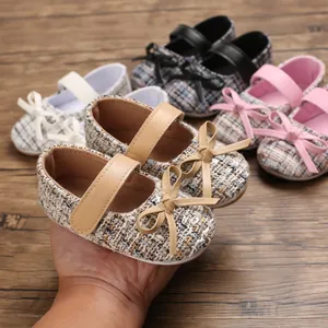 Detailansicht weicher Baby-Prinzessin-Lauflernschuhe mit Schleifen und Tweed-Textur.