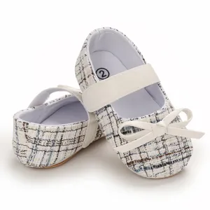 Nahaufnahme von Baby-Tweed-Mary-Janes mit eleganter weißer Schleife