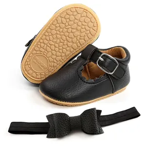 Vista dettagliata di eleganti scarpe da principessa nere per neonata e fascia con fiocco