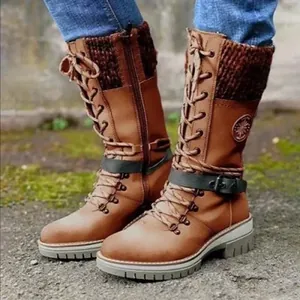 Detail of brown mid-calf boots featuring knit patchwork and decorative buckle strap.