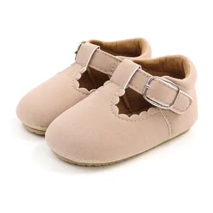 Detailed view of pink baby princess shoes with scalloped edges and metal buckle strap